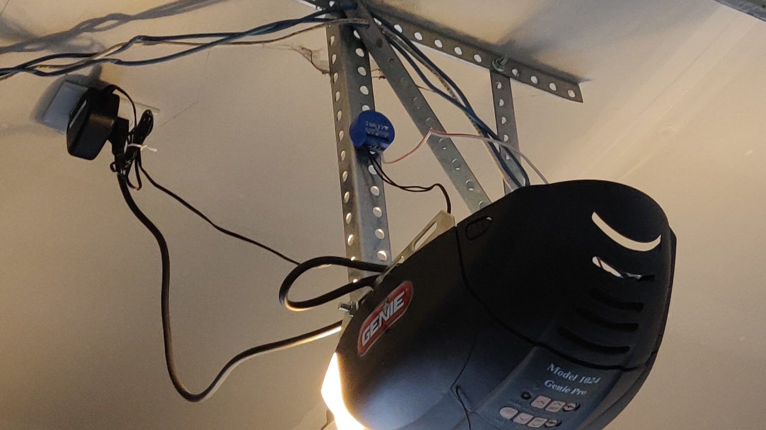 Ceiling-mounted garage door opener motor during a repair visit in the UAE