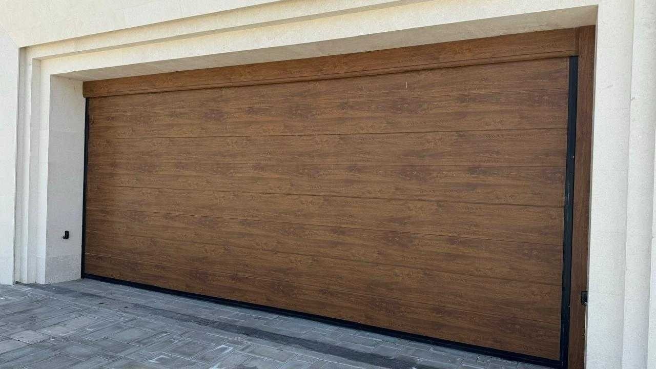Golden-oak wood-finish sectional garage door set in a cream stone villa façade